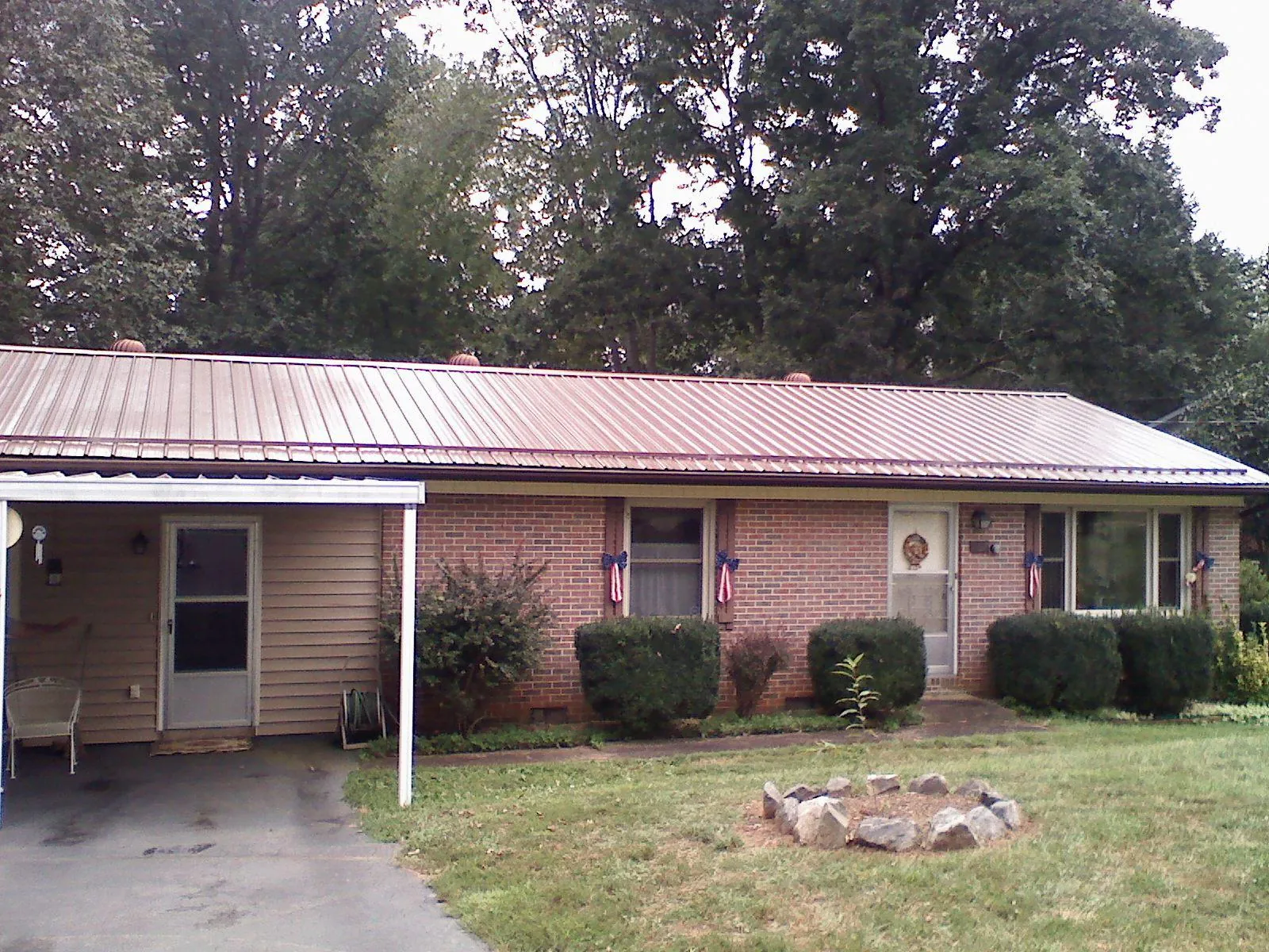 Bronze metal roof and carport on a brick ranch home — Roof Repair work by our crew in Denison